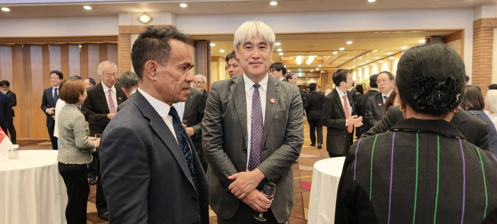 Timor-Leste representative in conversation with a Japanese guest at the reception